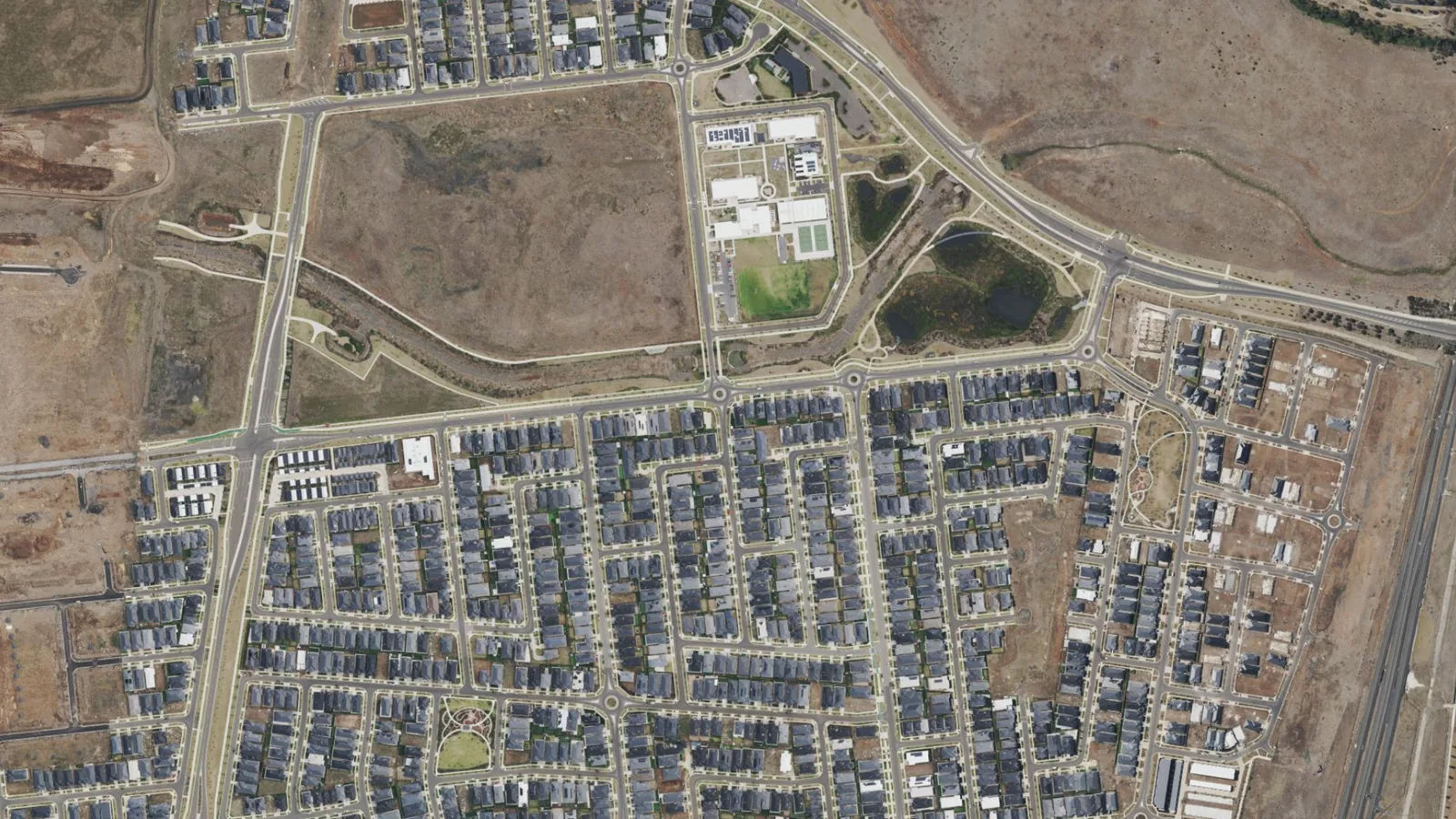 Aerial view of homes, roads, parkland and wetlands around Windermere Estate in Mambourin
